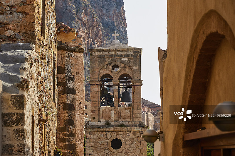 圣救世主基督教堂,艾尔科梅诺斯·克里斯托斯,带有十字架的古老钟楼,周围环绕着古老的石头建筑和岩石,莫奈姆瓦夏,莫奈姆瓦西,马尔瓦西,拜占庭小镇,岩石岛,堡垒,拉科尼亚,伯罗奔尼撒,半岛,希腊图片素材