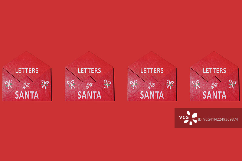 红木信件收纳盒，用于存放圣诞老人信件，一排排地排列在红色背景上。圣诞节、节日、装饰、庆祝、礼物、愿望和圣诞老人。图片素材