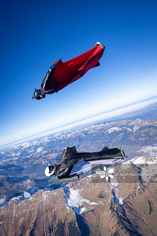 翼装飞行者在雪山前脸贴脸飞过图片素材