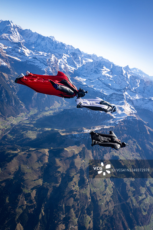 翼装飞行者编队飞越雪山图片素材