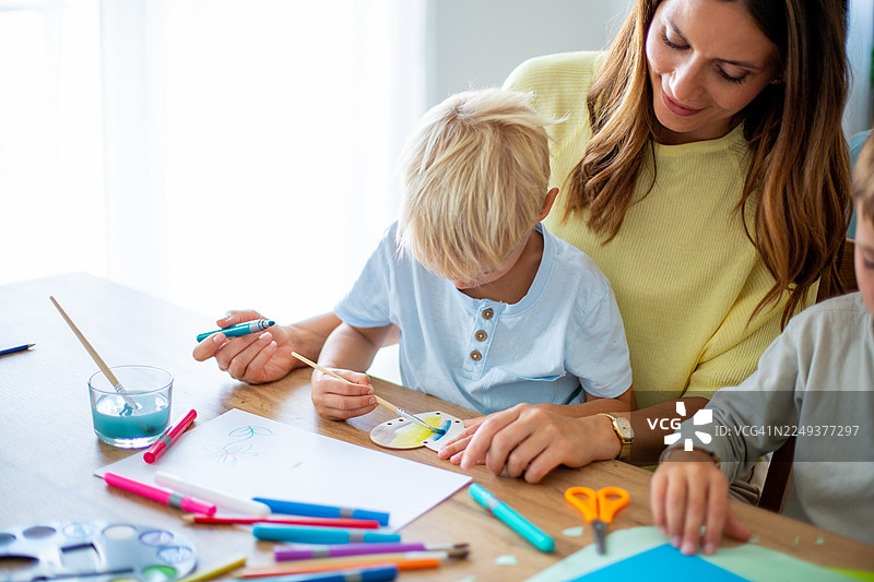 母亲和孩子们在家一起制作手工艺品图片素材