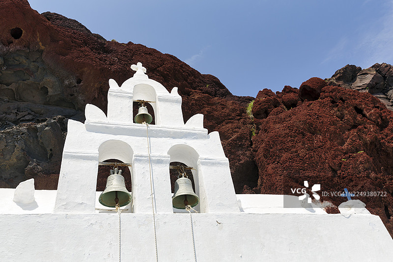 圣尼古拉奥斯·马夫罗拉迪教堂，钟楼位于红色岩壁前，火山岩，阿克罗蒂里，圣托里尼，基克拉泽斯，希腊图片素材