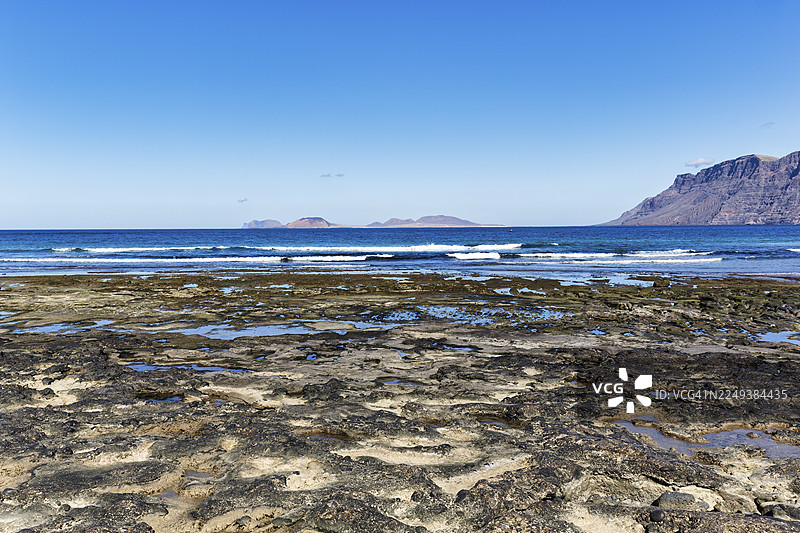 法马拉海滩，地平线上的拉格拉西奥萨岛，法马拉卡莱塔，兰萨罗特，西班牙图片素材