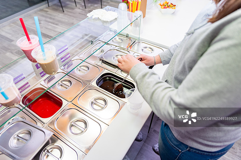 仅手部：女子在现代咖啡馆制作珍珠奶茶图片素材
