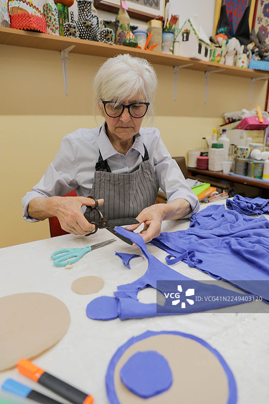 老妇人修剪纺织品和纸样图片素材