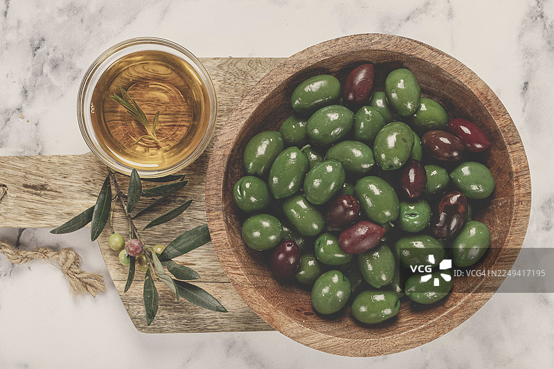 碗装的哈尔基迪基橄榄，经典的希腊绿橄榄，放在砧板上，俯视角度，无人物图片素材