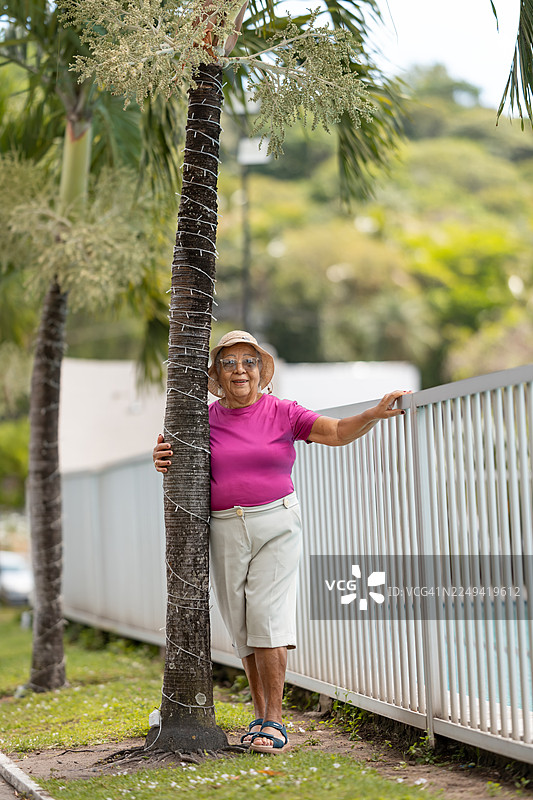 一位年长的女性在户外拥抱一棵树图片素材