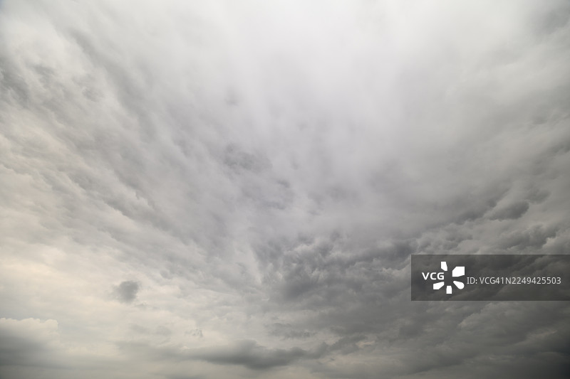 戏剧性的低角度视角，展现了聚集在天空中的风暴云，预示着即将到来的天气变化图片素材