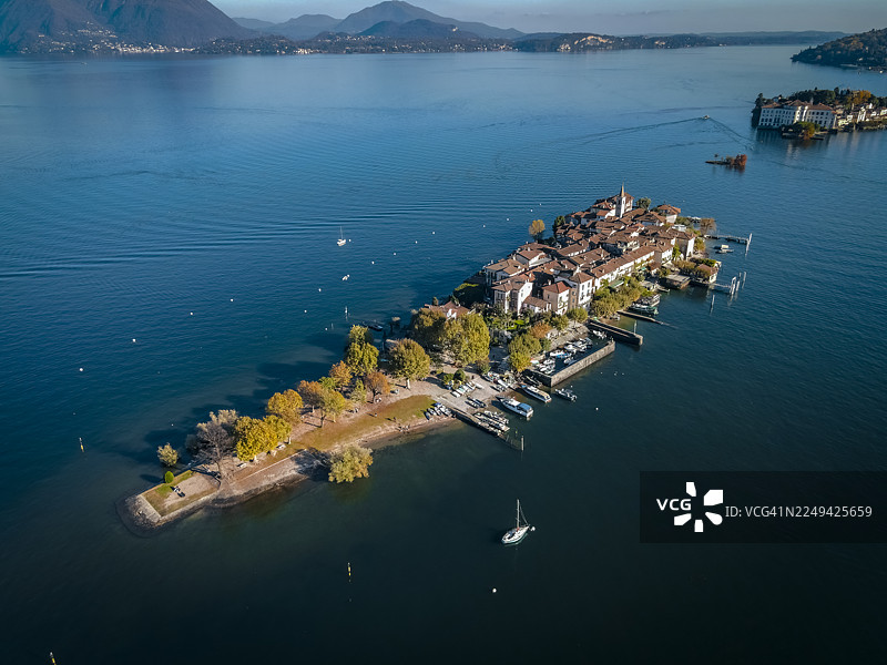 从高处俯瞰马焦雷湖上的渔夫岛(Isola Superiore / Isola dei Pescatori),背景是停靠的船只和远处的山峦图片素材