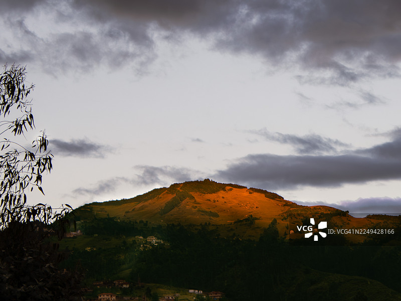 日落时分，多云的天空下，山峰被金色的光芒照亮，厄瓜多尔，阿索格斯图片素材
