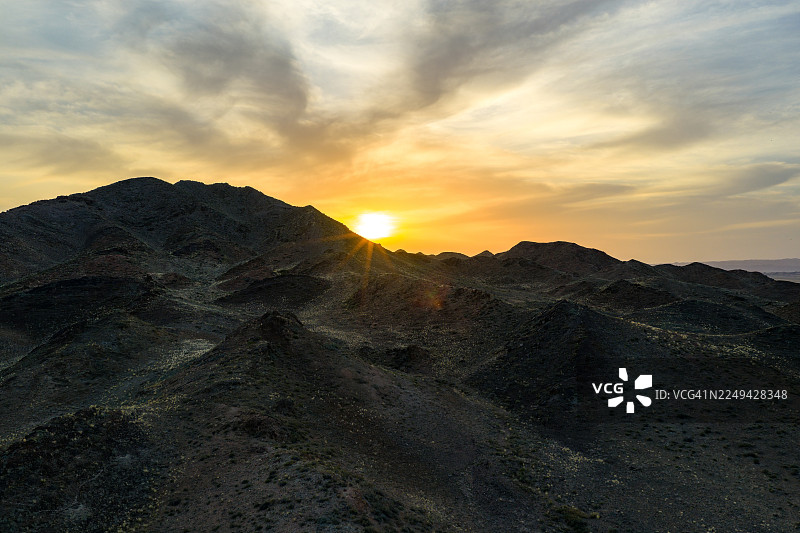 哈萨克斯坦阿拉木图，查林峡谷，橙色天空下的壮丽日落，云彩点缀其间图片素材