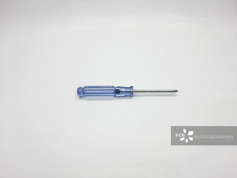 白色背景下蓝色手柄螺丝刀的特写，突出工具和维修概念图片素材