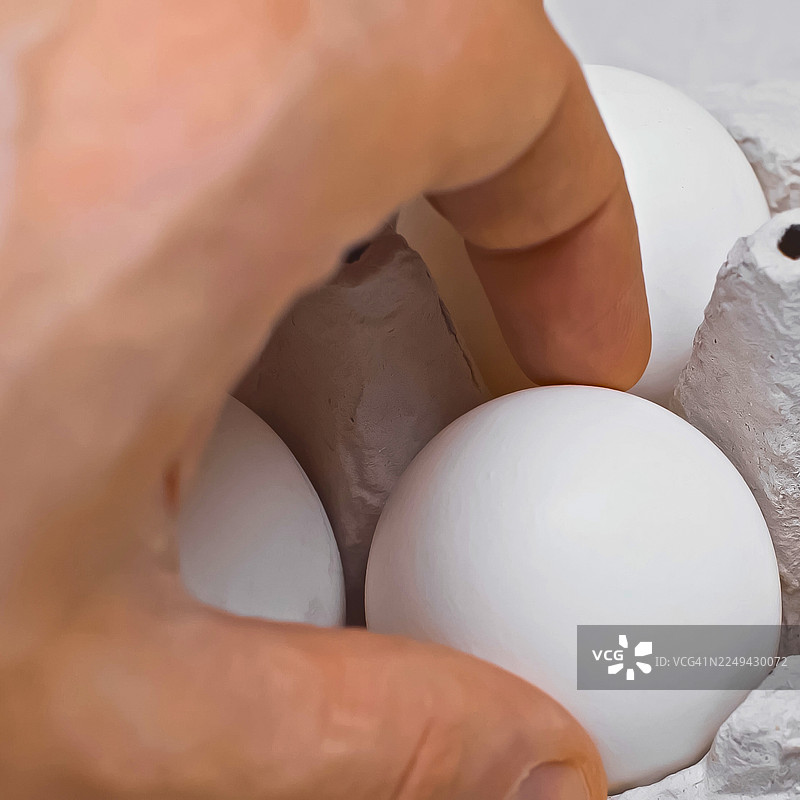 裁剪的手，从蛋盒中放入或取出鸡蛋，突出新鲜农产品和烹饪食材图片素材