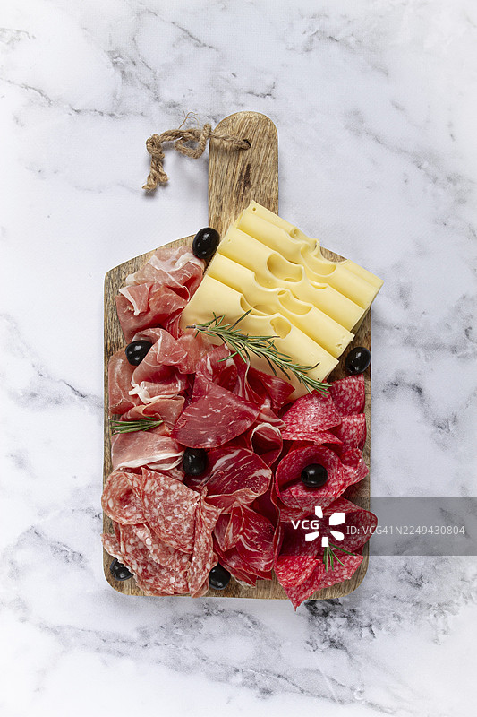 什锦肉类、开胃菜、意大利熏火腿、萨拉米香肠和火腿，搭配马苏丹奶酪和橄榄，摆放在木板上，早餐，俯视，特写，无人图片素材