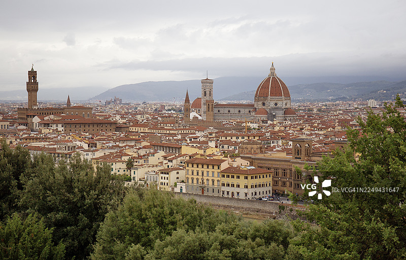 俯瞰意大利佛罗伦萨历史名城，云层下的标志性建筑与葱郁绿植图片素材