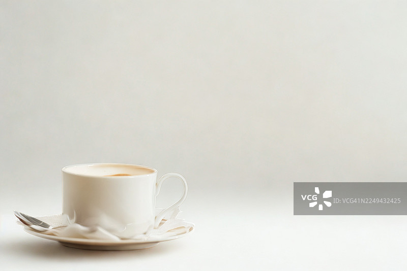 白底白瓷咖啡杯碟及汤匙的特写，提供复制空间图片素材