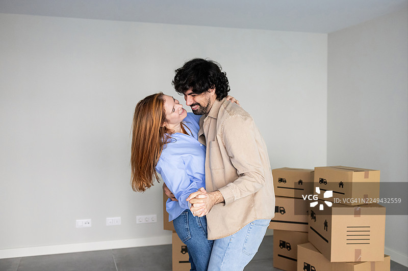 一对情侣在搬入新家后，在新家跳舞庆祝图片素材