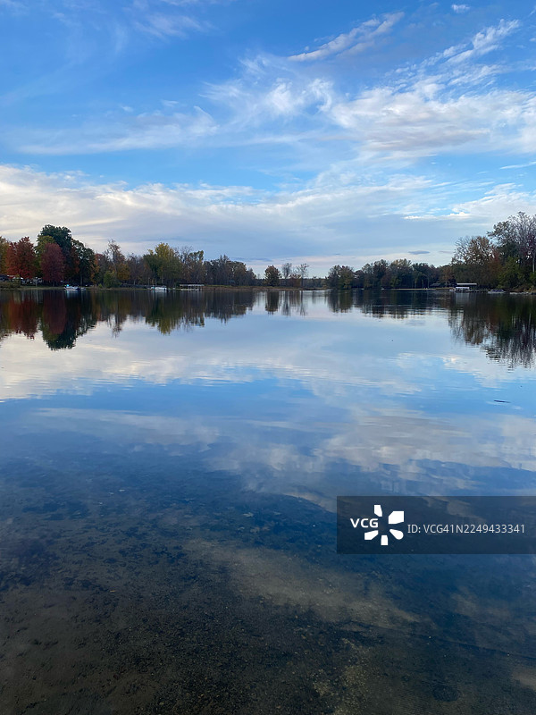 马歇尔，美国，一张宁静湖泊的风景照，湖面映照着湛蓝的天空和色彩斑斓的秋季树木图片素材