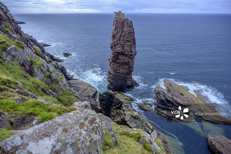 壮丽的海岸风光，一座高耸的海蚀柱矗立在多云的天空下，海浪拍打着礁石，英国，英国，斯托尔老人岩图片素材