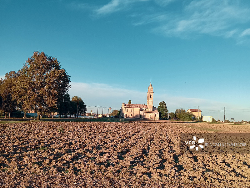 意大利圣米歇尔乡村风光，有历史悠久的教堂和耕地，蓝天下的景致图片素材