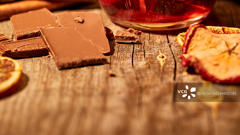 从高处俯瞰，乡村木桌上摆放着巧克力棒、干果和饮品，营造出舒适惬意的奢华氛围图片素材