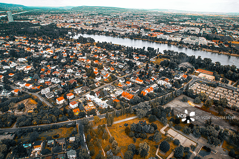 高角度航拍，展现了房屋、树木和河流的广阔城市景观，天空辽阔，体现了城市发展与自然的融合，维也纳，奥地利图片素材