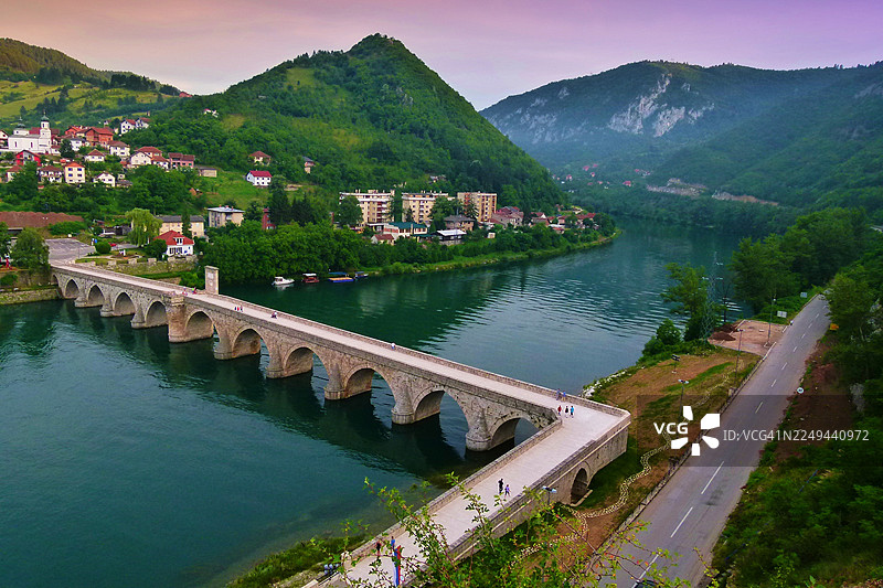 夕阳下的维谢格拉德镇和周边群山，博斯尼亚和黑塞哥维那，德里纳河上的历史悠久的梅赫迈德帕夏索科洛维奇桥图片素材