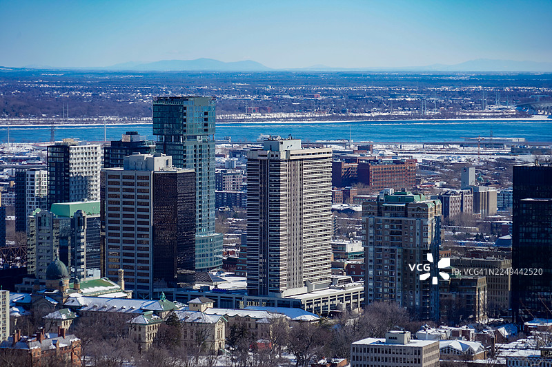 冬季，加拿大，晴朗的蓝天下，现代城市建筑和冰封河流的高角度景观图片素材