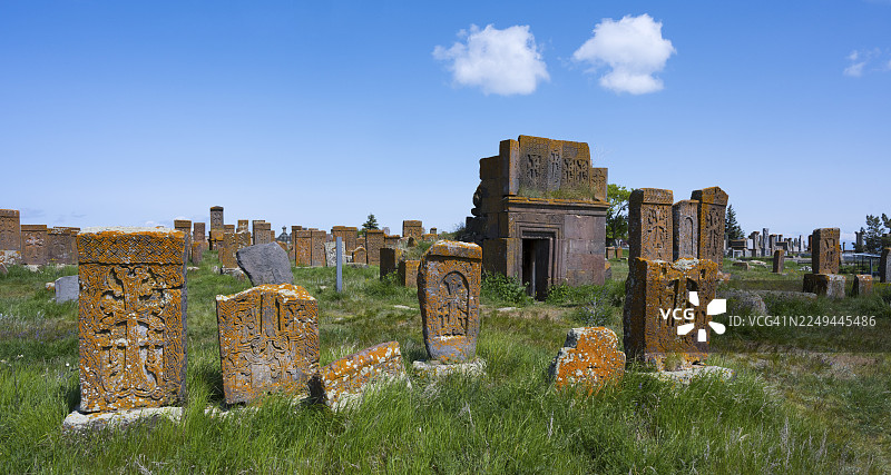 古老的墓地，装饰精美的墓碑和一座小建筑在蓝天下，十字石，哈奇卡石，世界上最大的哈奇卡石阵，诺拉图斯墓地，格加尔库尼克省，亚美尼亚图片素材