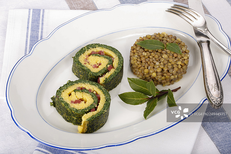 南德美食，玉米糊菠菜卷配阿尔布施扁豆，盛放在托盘上，有月桂叶、扁豆蔬菜、烟熏肉、培根丁，健康，美食摄影，影棚，德国图片素材