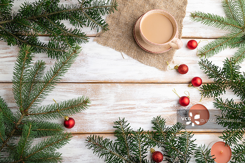 圣诞节或新年构图。装饰品、红色球、杉树和云杉枝、咖啡杯、白色木质背景上的蜡烛。俯视，复制空间，平面图图片素材