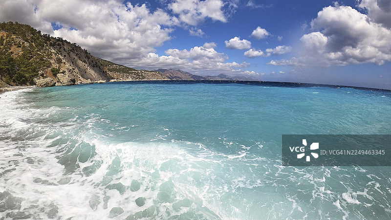 深邃的蓝海，远方有海岸线，天空中有洁白的蓬松云朵，卡托拉克科斯海滩，几乎未被开发的宁静海湾，无法驾车到达，卡托拉克科斯，东海岸，卡尔帕索斯，佐泽卡尼萨群岛，希腊岛屿，希腊图片素材