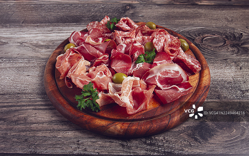 什锦切片肉开胃菜，包括意大利熏火腿、萨拉米香肠和火腿，配以橄榄，放在木板上，俯视早餐特写，无人图片素材