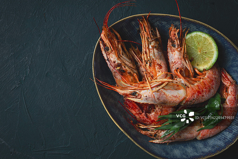 澳大利亚小龙虾，新鲜冷冻在冰上，俯视角度，配有青柠和绿叶图片素材
