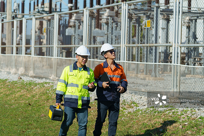 工程师正在检查一座大型风力涡轮机的运行情况，该涡轮机正在风力发电场中发电。（照片）图片素材