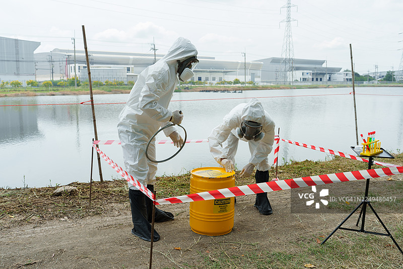 生态学家们身着防护服，在养殖水生动物的农场池塘中检查水质，并采集水样进行分析。图片素材