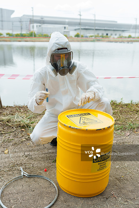 生态学家们身着防护服，在养殖水生动物的农场池塘中检查水质，并采集水样进行分析。图片素材