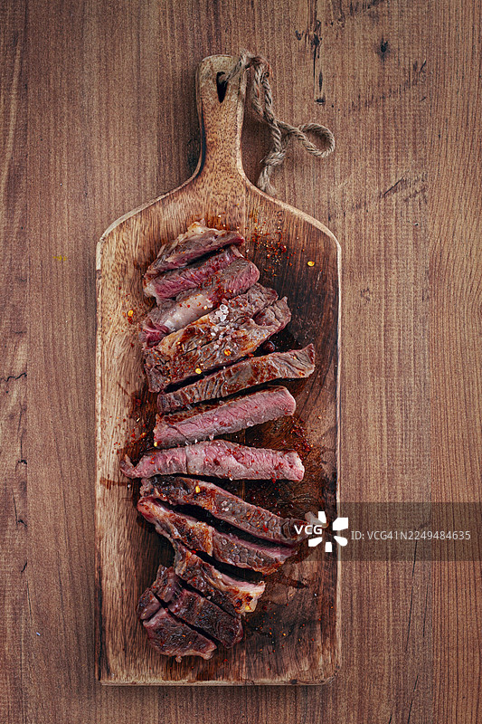 中等熟度、切片眼肉牛排，烤牛仔牛排，放在砧板上，特写，自制，俯视，无人图片素材