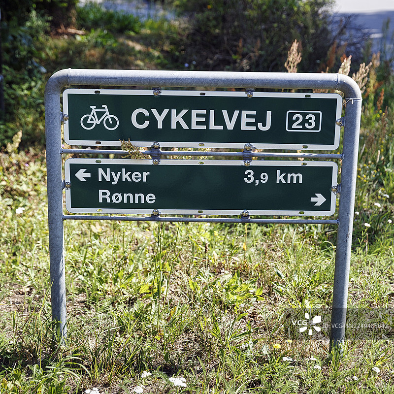 丹麦语路牌,标有“Radweg 23”,指示到尼克尔(Nyker)和容讷(Rønne)的距离,穿越海岸风景的自行车之旅,博恩霍尔姆,丹麦图片素材