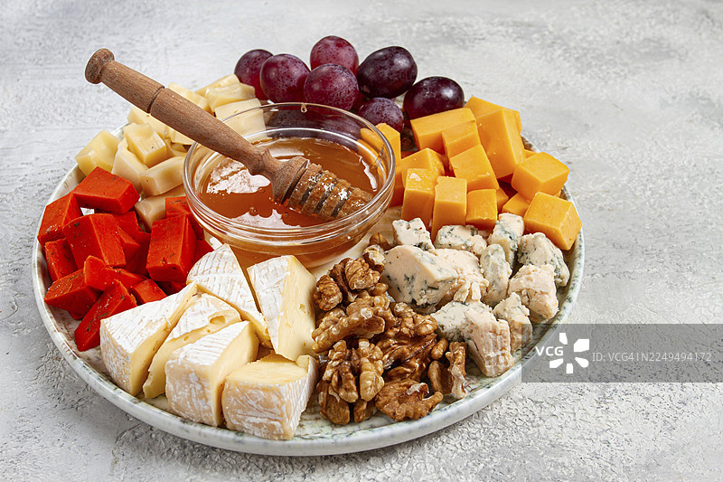 开胃菜，什锦奶酪配坚果和蜂蜜，放在圆盘上，俯视，无人图片素材