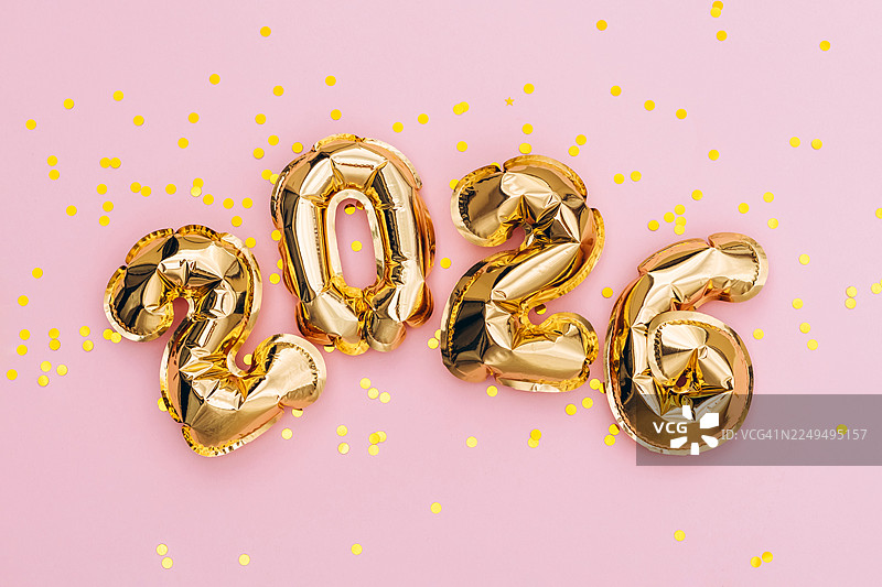 金色2026气球和纸屑，背景为粉色。图片素材