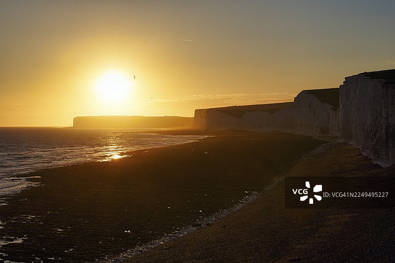 夕阳下的鹅卵石海滩，七姐妹白垩悬崖，逆光，伯林加普，东萨塞克斯，南唐斯，英格兰，英国图片素材