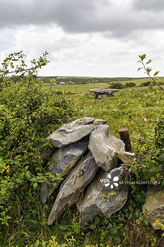 越过石墙的视野，爱尔兰克莱尔郡草地上一处未知的古代巨石墓图片素材
