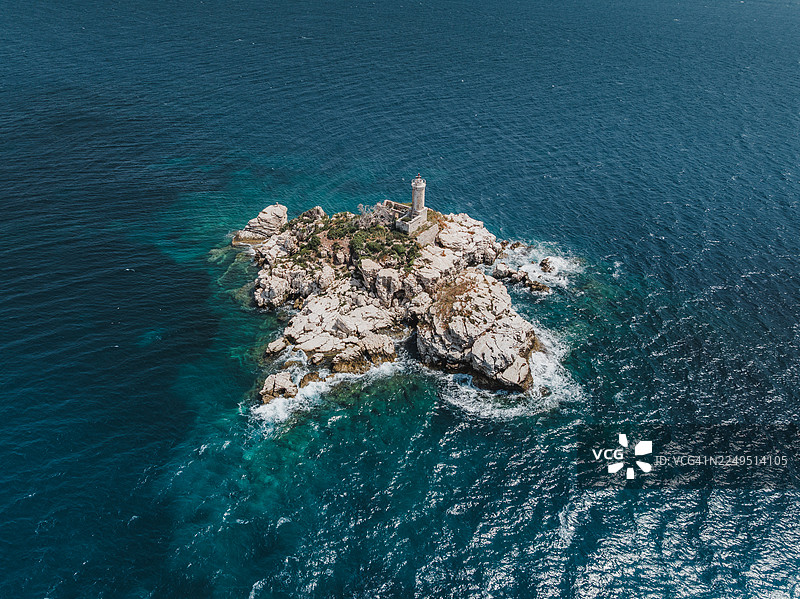 从高处拍摄的灯塔照片，位于爱奥尼亚海上的一座小岩石岛上，拍摄地点为阿尔巴尼亚萨兰达附近的海岸线图片素材