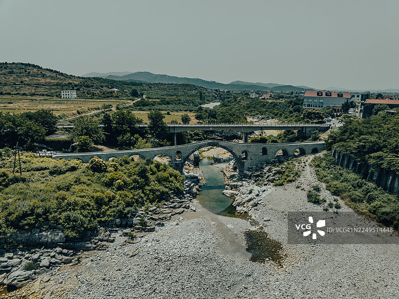 鸟瞰图，展示了一座桥梁横跨阿尔巴尼亚斯库台县一条干涸的河流图片素材
