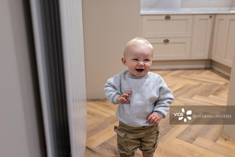 蹒跚学步的幼儿首次来到新家图片素材