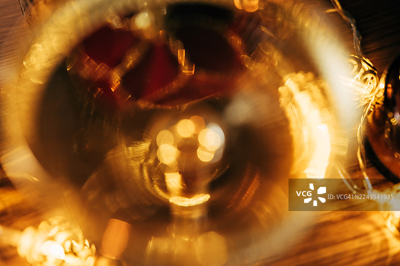 节日虚化：带有快乐节日光晕和温暖闪光的深色模糊圣诞灯背景图片素材