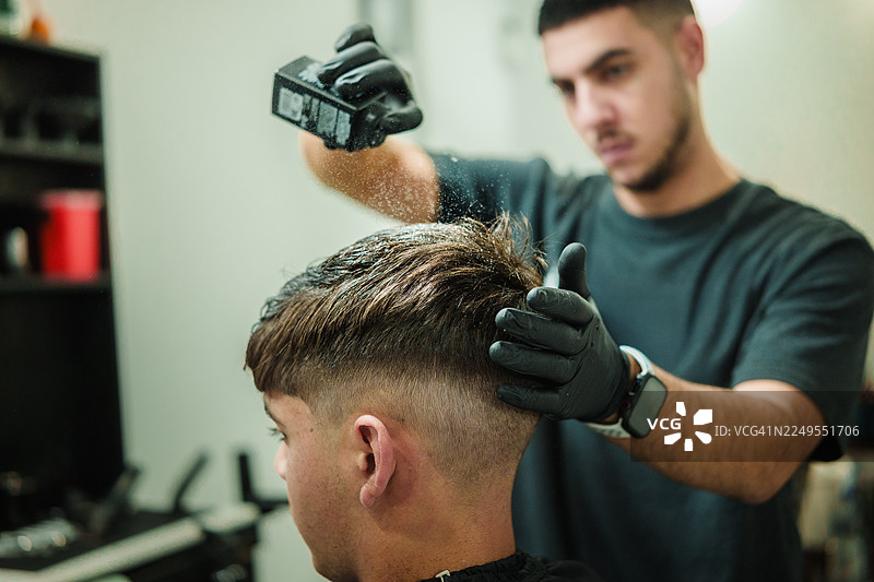 理发师为顾客的头发涂抹造型粉图片素材