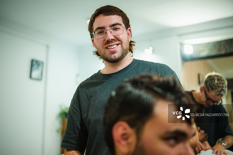 理发店里一位留着新鲻鱼发型的快乐男士图片素材