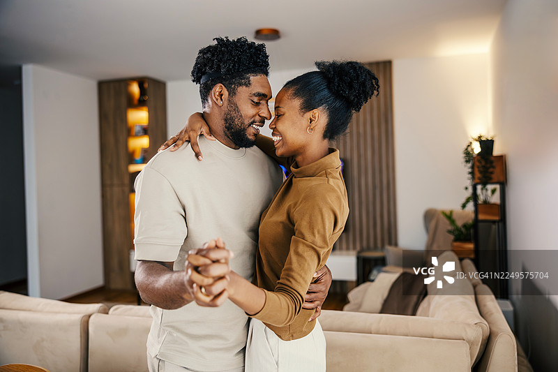 快乐的黑人情侣在客厅里共舞图片素材
